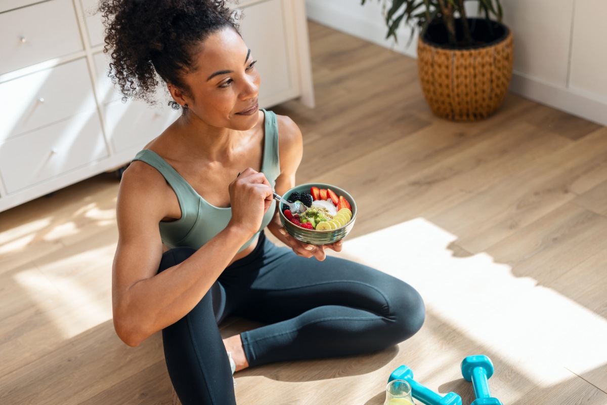 athletic woman eating a healthy fruit bowl