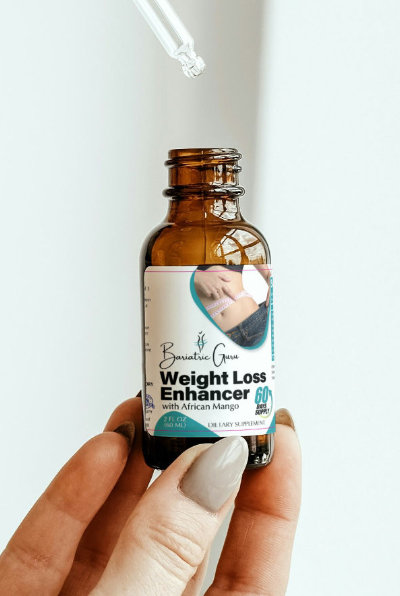 A hand holds a brown dropper bottle labeled "Weight Loss Enhancer with African Mango 600 mg," with a dropper positioned above the bottle.